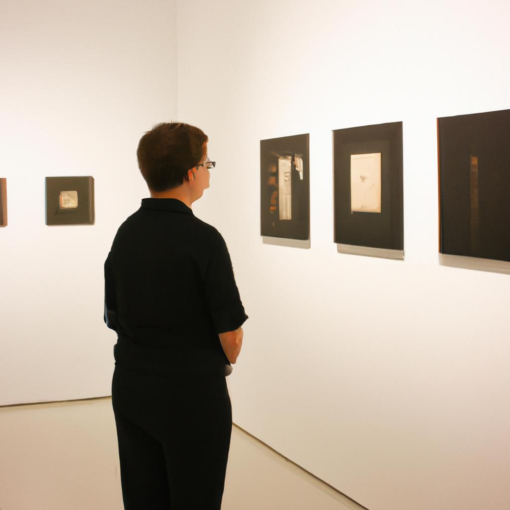 Person studying artwork in gallery